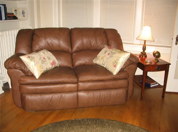 Кожаный диван отлично подойдет для маленького домашнего кабинета