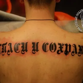 Татуировка на спине у парня - надпись на русском